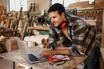 Das Bild zeigt einen Mitarbeiter im Vertriebsinnendienst. Er sitzt am Schreibtisch und arbeitet am Laptop.